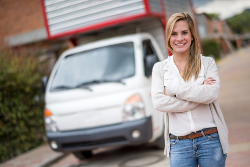 Young woman with a moving van looking very happy