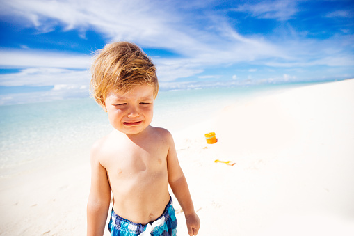 Beach, relax and travel child portrait with smile on sand for peaceful summer break. Young and happy boy on the beach, enjoying freedom and leisure with seaside walk.