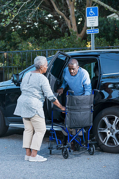 casal estacionado na vaga de estacionamento para portadores de necessidades especiais - couple dependency standing men - fotografias e filmes do acervo