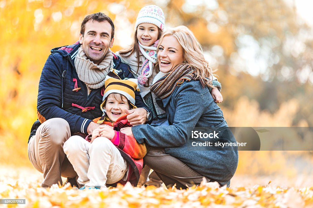 Autumn family portrait. Cheerful parents enjoying with their children outdoors and looking at the camera.   2015 Stock Photo