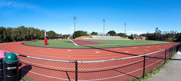 Football and track stadium panorama under blue sky. Horizontal.