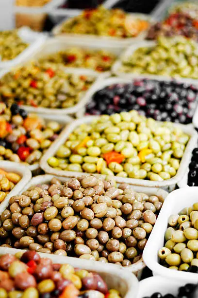 A colorful assortment of cured olives on display at an outdoor market in Paris, France.
