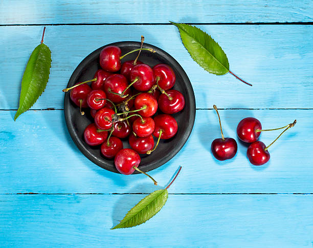 istock Cherries on a blue wooden background. Top view 539208666