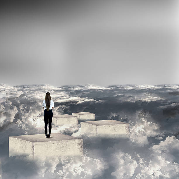 istock Businesswoman standing on concrete blocks above clouds 539212322