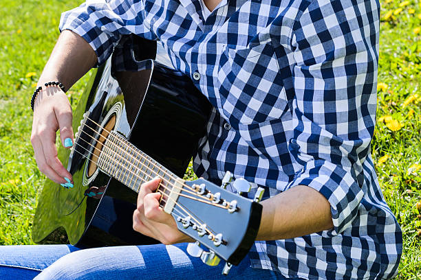istock girl on a green meadow playing guitar 539212534