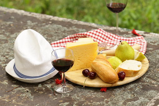 cheeseboard with pears and wine on a table in the garden