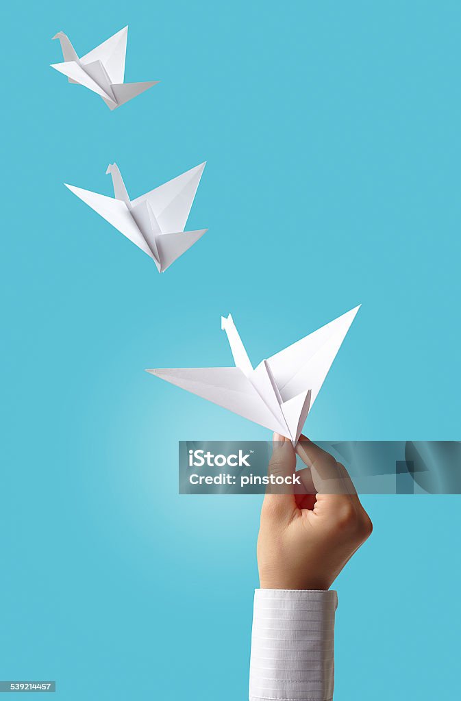 Freedom Woman flying cranes to hope. White origami cranes flying to freedom from hand. 2015 Stock Photo