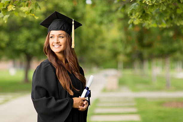 hermosa mujer sosteniendo diploma universitario de posgrado - poses para fotos de graduación fotografías e imágenes de stock