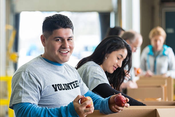 istock Hispanic man sorting donations in food bank with volunteers 539215081