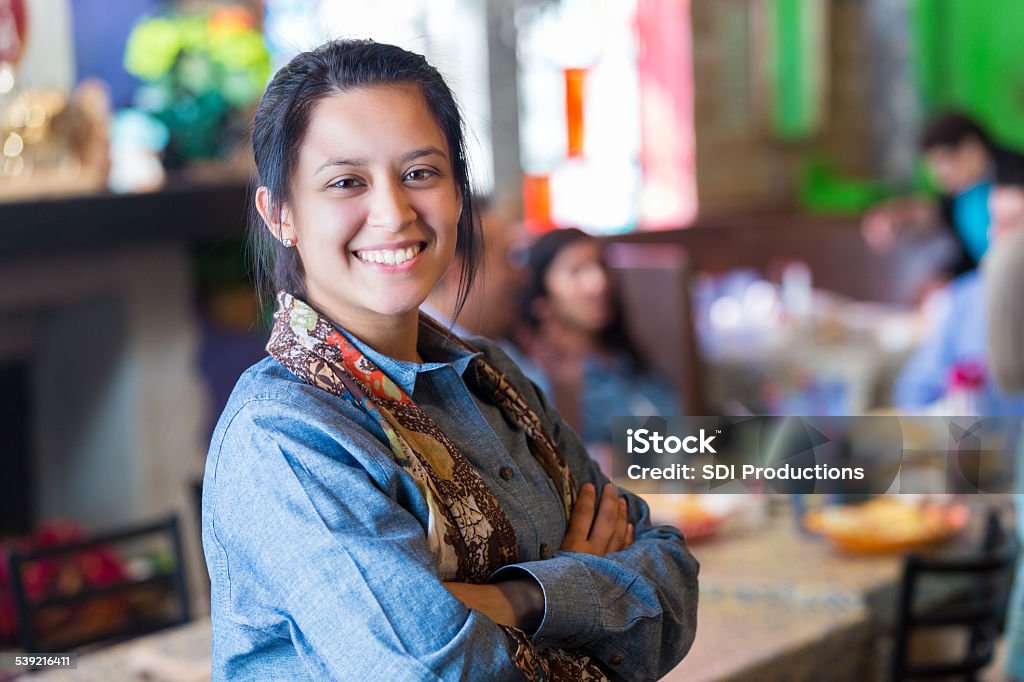 Pretty Hispanic young woman standing in family owned Tex-Mex restaurant Women Stock Photo