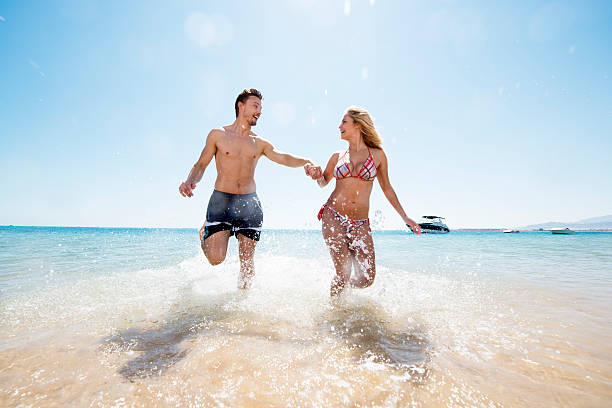 istock Happy couple running through sea and having fun. 539216681