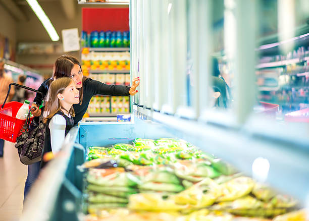 mutter und tochter in der nähe von gefrorene lebensmittel im supermarkt - gefrierkost stock-fotos und bilder