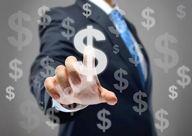 Photo of Businessman touching dollar signs on virtual screen.