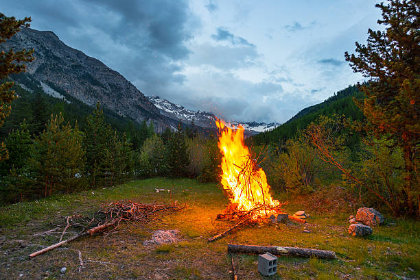istock Burning camp fire in alpine woodland with dramatic sky 539217940