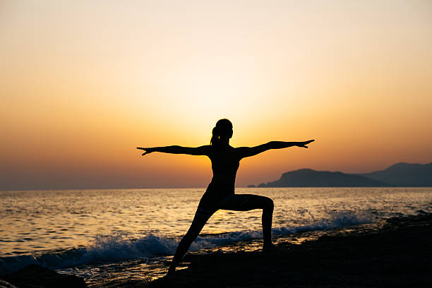 istock Young healthy woman practicing yoga on the beach at sunset 539218014