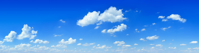 White puffy cumulus clouds on summer blue sky.