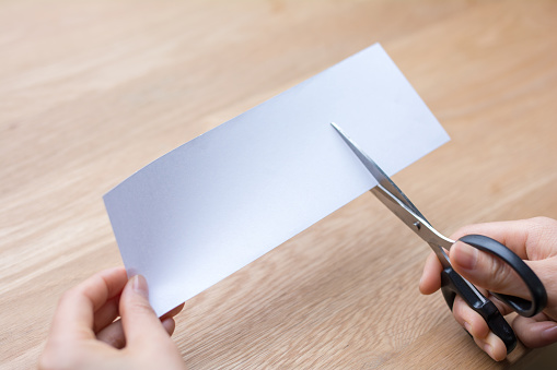 woman cutting white paper