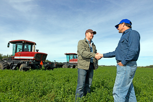 A royalty free image from the farming industry of two farmers shaking hands.