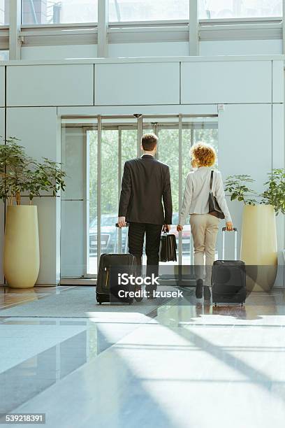 Businessman And Businesswoman On Business Travel Stock Photo - Download Image Now - Hotel, Leaving, Men