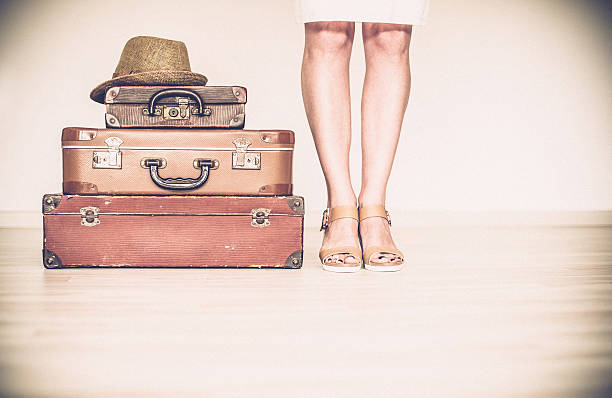 istock Woman stands beside a suitcase 539219748