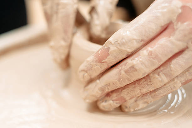 istock Potters dirty hands on potter wheel close-up 539222058
