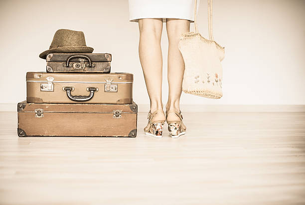 istock Woman stands beside a suitcase 539222124