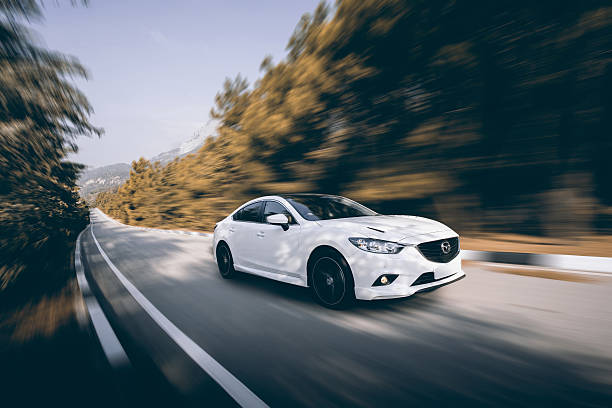 Car Mazda driving on road at daytime Crimea, Russia - September 20, 2015: Mazda 6 car drive on road at daytime headlight photos stock pictures, royalty-free photos & images