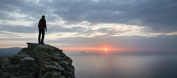 istock Man looks at the seascape panorama from a cliff 539233485