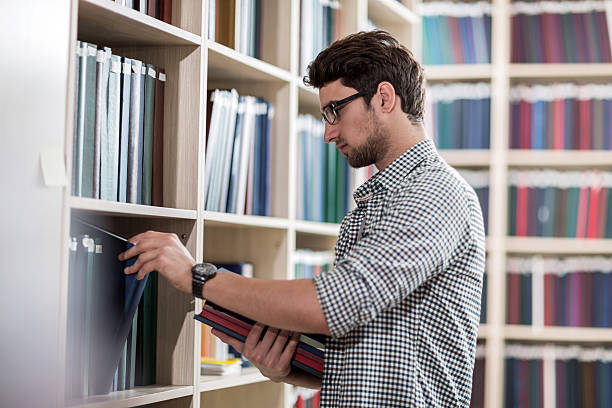 istock Young man choosing books in the library. 539234033
