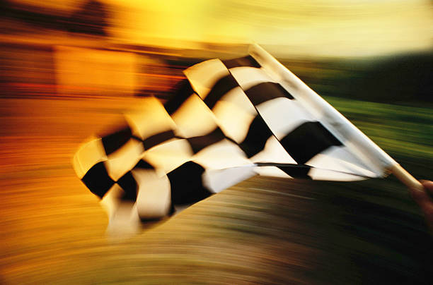 bandeira quadriculada acenando em um carro de corrida. - checkered flag flag the end motorized sport - fotografias e filmes do acervo