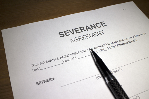 Someone filling out Severance Agreement.