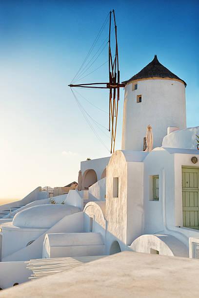 traditionelle europäische windmühle in griechischen insel santorin auf sonnenuntergang - santorini greece oia sunset stock-fotos und bilder