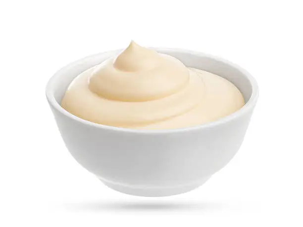 Photo of Mayonnaise in small bowl isolated on white background.