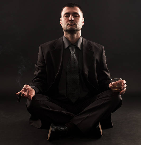 istock Businessman doing yoga with cigar and whiskey 539235943