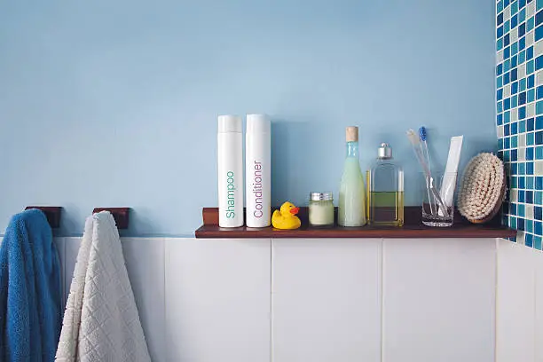 Blue wall and a shelf in the bathroom with hygiene accessories