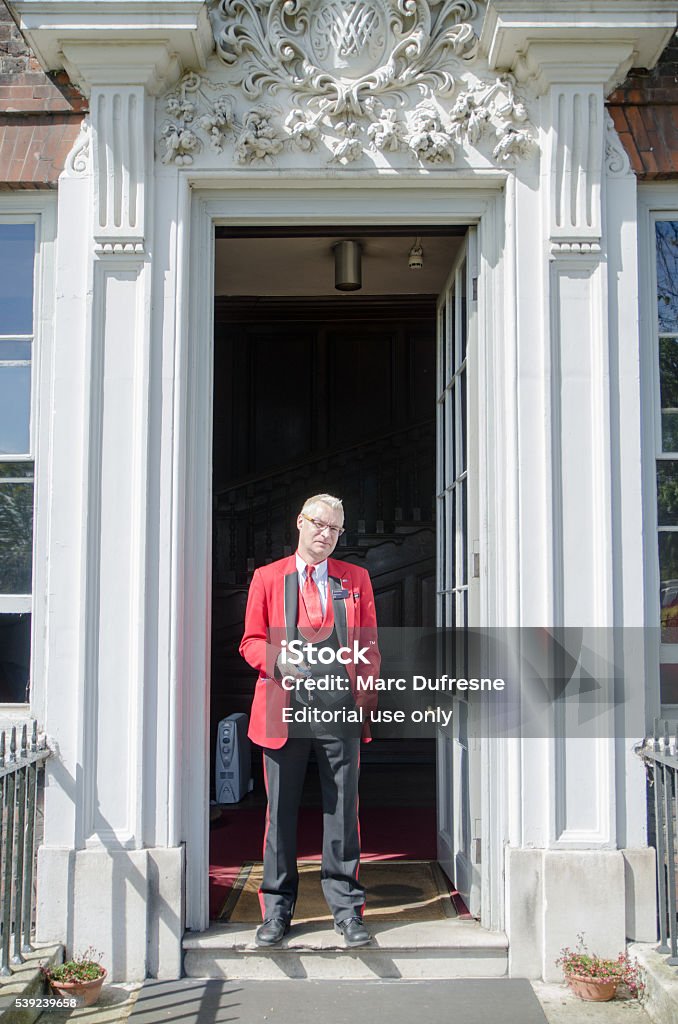 Típico inglés hombre parado en la puerta con llave - Foto de stock de Mayordomo libre de derechos