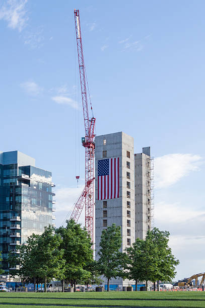 South Boston new construction Boston, Massachusetts, USA - June 9, 2016: Huge American flag adorns buildings under construction along Harborwalk in South Boston harborwalk stock pictures, royalty-free photos & images