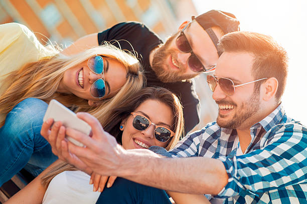 Young friends making selfie outdoors while enjoying together.