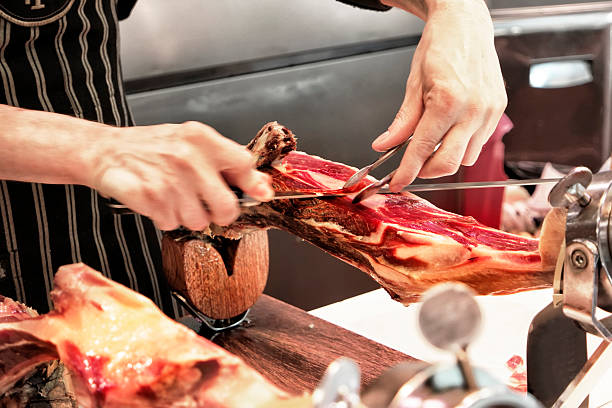 istock Professional cutter carving slices from a whole boneSpanish ham 539242046