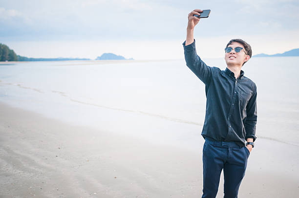 istock Business man working with smartphone beach background 539242368