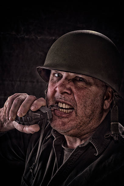 istock Vintage Army Soldier pulling pin on hand grenade with teeth 539244259