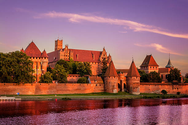 Medieval Malbork castle on the river Nogat, Poland Malbork, Poland - August 06, 2015:Medieval Malbork castle on the river Nogat in sunset, Poland. The largest castle in the world by surface area, and the largest brick building in Europe. Historical capitol of the Teutonic Order - Crusaders  malbork photos stock pictures, royalty-free photos & images