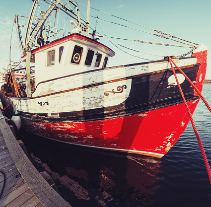 A wide view of a scallop fishing boat moored in a Nova Scotian fishing village.