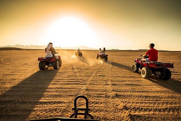 istock People driving quad bikes in the desert. 539246193