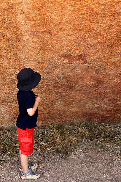 niño mirando a bushman obras de arte en namibia, áfrica - cave painting rock africa bushmen fotografías e imágenes de stock