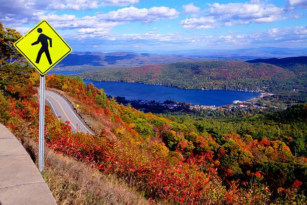 Photo of Pedestrian Crossing Sign at Top of Autumn Mountain with Lake