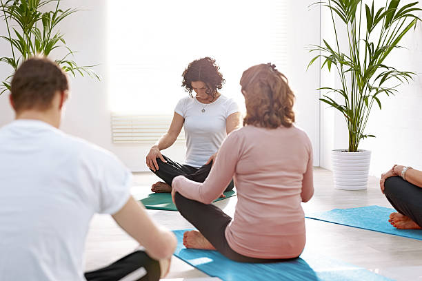 istock People meditating in gym 539247041