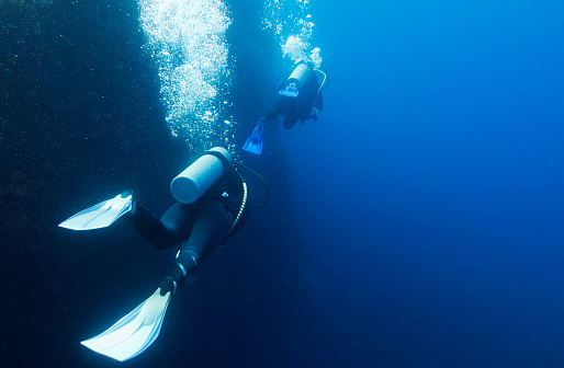 Divers in in deep blue with copy space on the right.