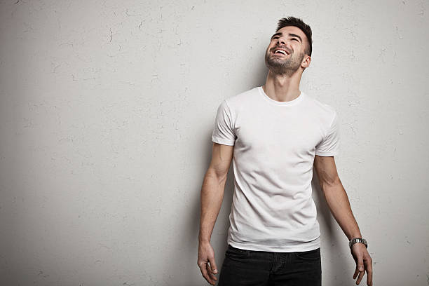 uomo sorridente in t-shirt bianca - moving up looking men people foto e immagini stock