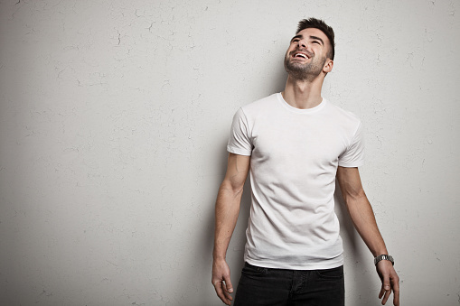 Cheerful man with stubble in blank t-shirt, front, studio